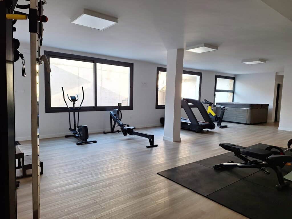 Strefa fitness z bieżnią, rowerkiem, sprzętem treningowym i sauną na osiedlu