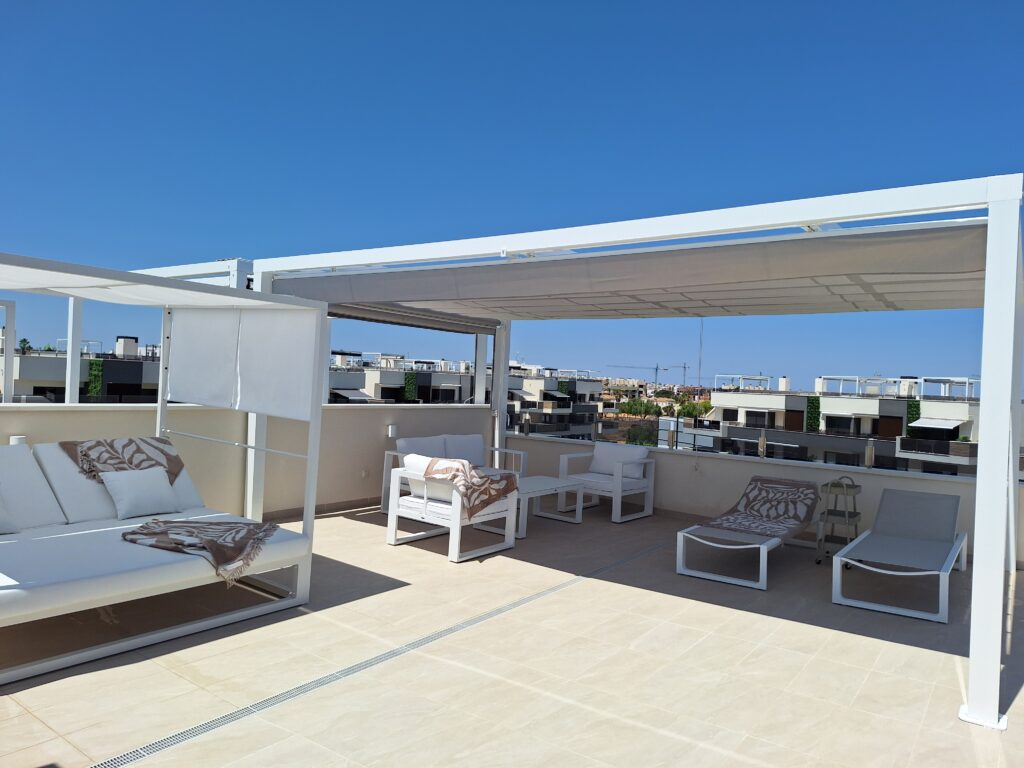 Taras dachowy z pergolą, leżanką i strefą wypoczynku w apartamencie na Costa Blanca